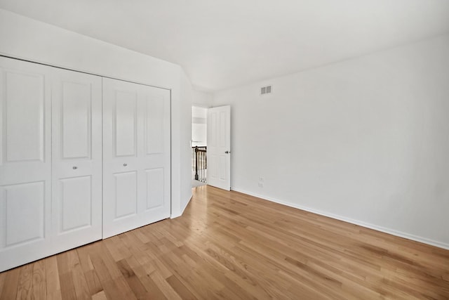 unfurnished bedroom featuring light hardwood / wood-style flooring and a closet