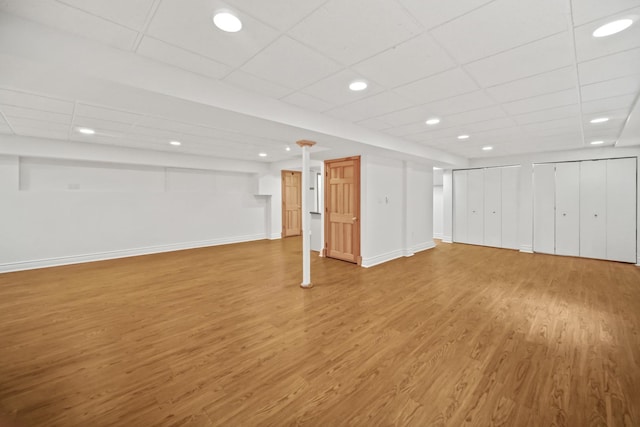 basement with hardwood / wood-style floors and a drop ceiling