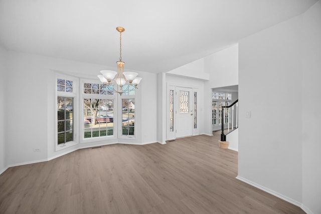 unfurnished dining area featuring hardwood / wood-style flooring and a notable chandelier