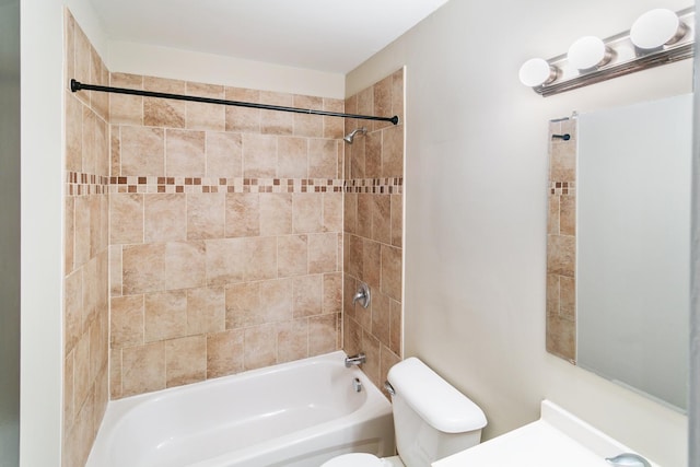 bathroom featuring tiled shower / bath combo and toilet