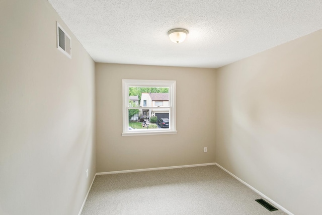 carpeted spare room with a textured ceiling