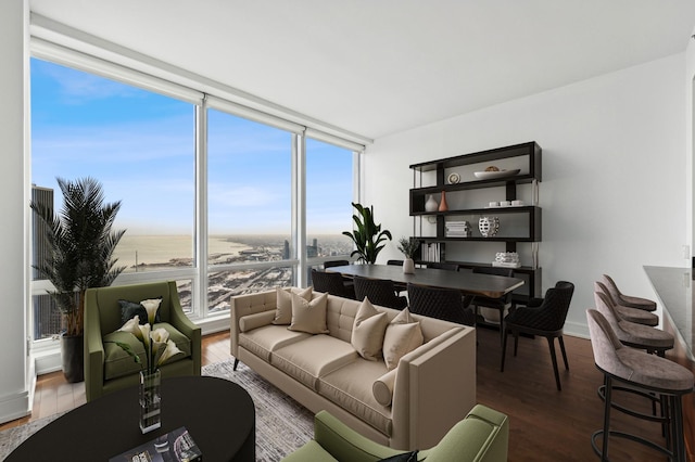 living room featuring dark hardwood / wood-style flooring, a water view, and expansive windows