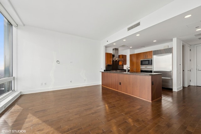 kitchen with built in appliances, a healthy amount of sunlight, dark hardwood / wood-style flooring, and range hood