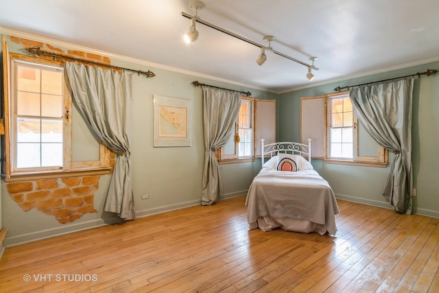 bedroom featuring ornamental molding and light wood-type flooring