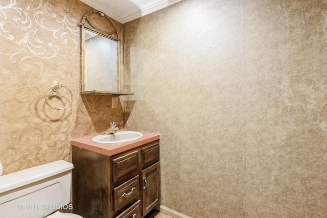 bathroom featuring vanity, crown molding, and toilet