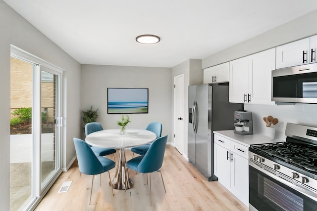 kitchen featuring white cabinets, light wood-type flooring, and appliances with stainless steel finishes