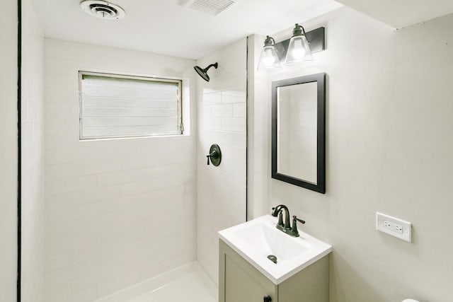 bathroom with vanity and tiled shower