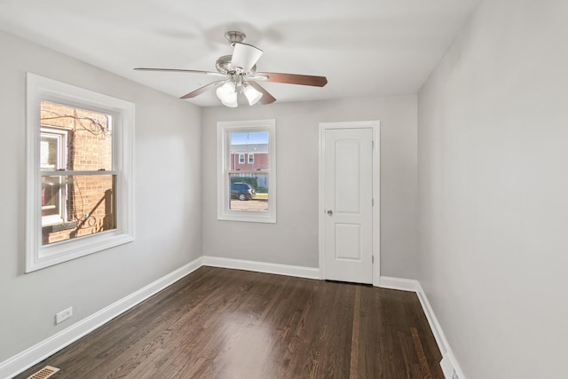 spare room with dark hardwood / wood-style floors and ceiling fan