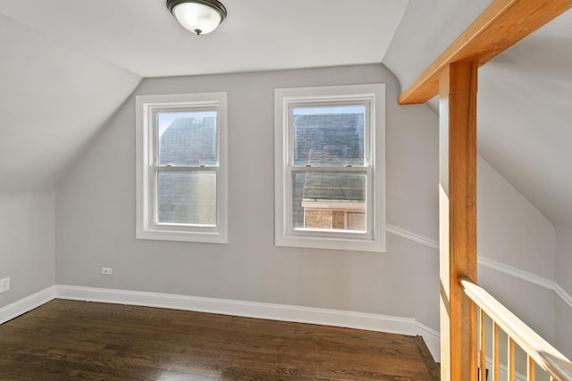 additional living space with dark hardwood / wood-style flooring and vaulted ceiling