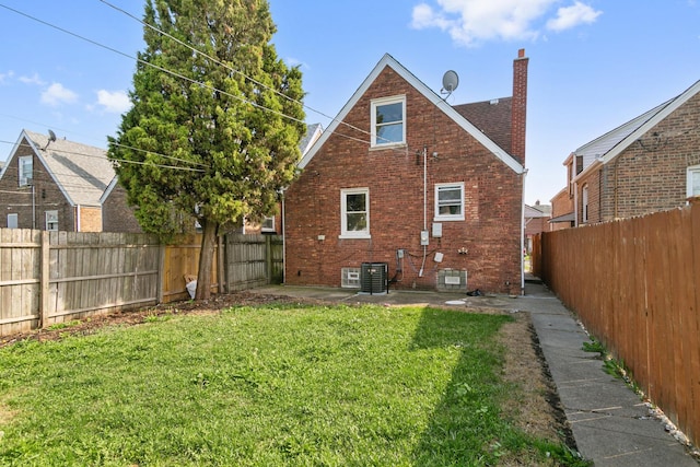 rear view of house featuring a yard and central AC