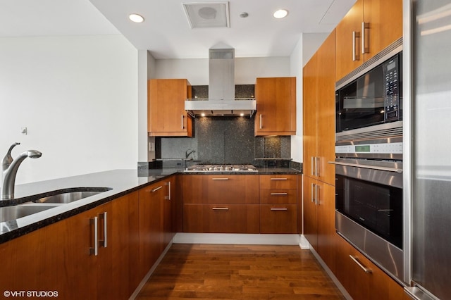 kitchen featuring sink, dark hardwood / wood-style flooring, dark stone counters, extractor fan, and appliances with stainless steel finishes