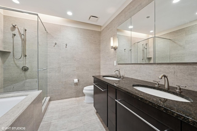 full bathroom with vanity, toilet, tile walls, and independent shower and bath