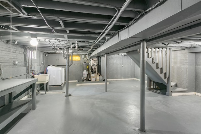 basement with sink, water heater, and washer and clothes dryer