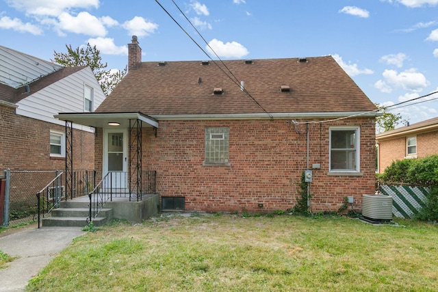 rear view of property featuring central AC unit and a yard