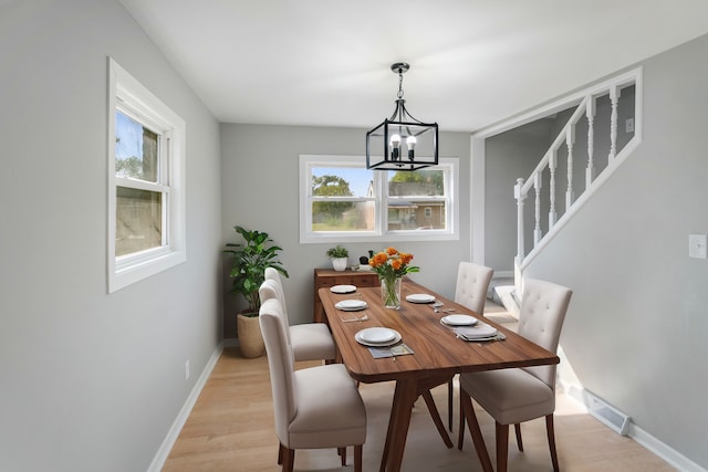 dining room with a chandelier, light wood-type flooring, and a wealth of natural light