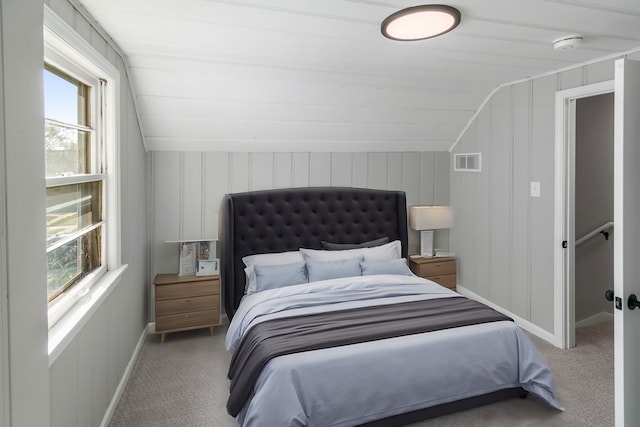 carpeted bedroom with multiple windows and lofted ceiling