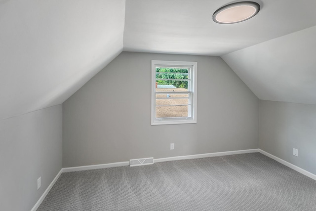 bonus room featuring vaulted ceiling and carpet