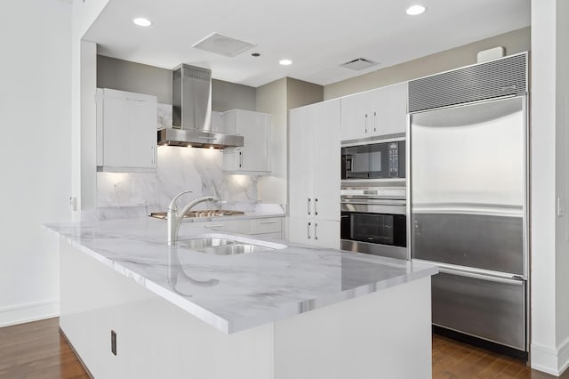 kitchen featuring sink, built in appliances, extractor fan, and white cabinets