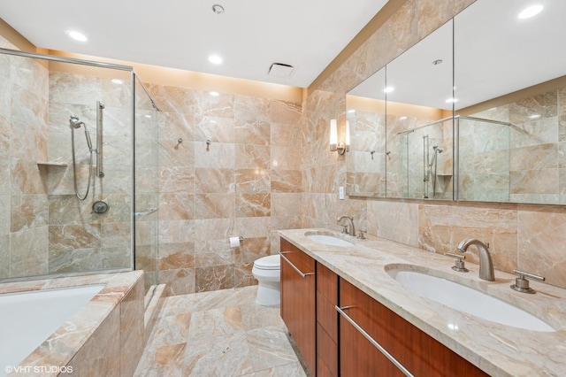 full bathroom with vanity, separate shower and tub, tile walls, and toilet