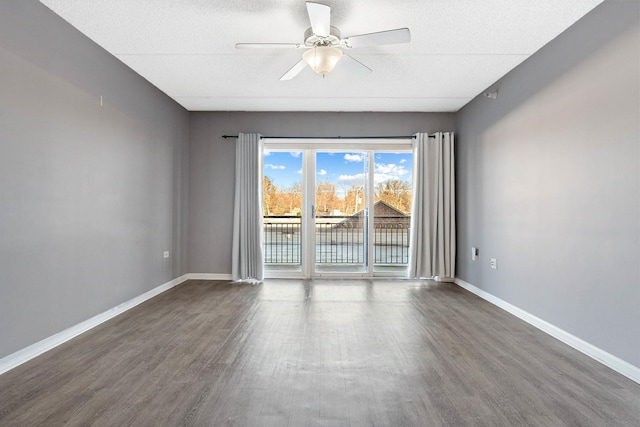 spare room featuring a textured ceiling, ceiling fan, and dark wood-type flooring