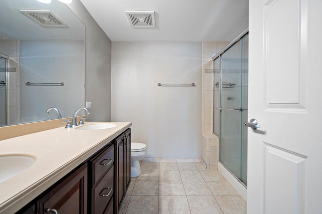 bathroom featuring tile patterned flooring, vanity, an enclosed shower, and toilet