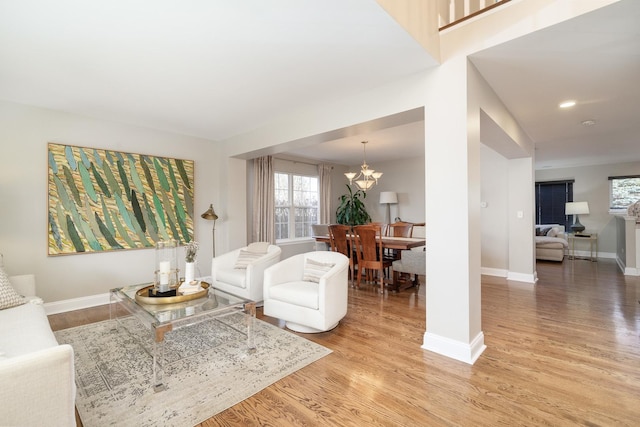 living room with light wood-type flooring and an inviting chandelier