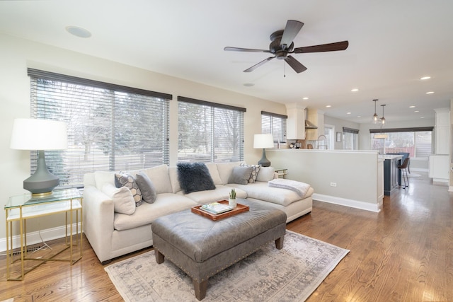 living room featuring hardwood / wood-style floors and ceiling fan