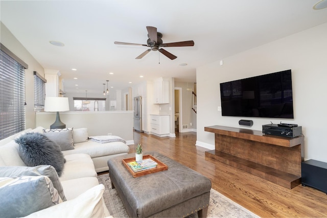 living room featuring light hardwood / wood-style floors and ceiling fan