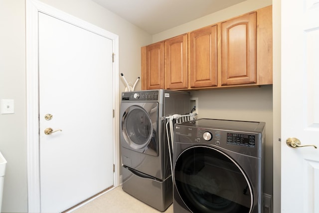 laundry room with separate washer and dryer and cabinets