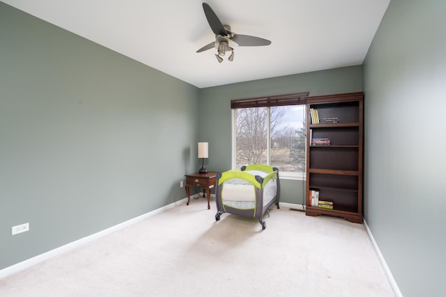 living area featuring light carpet and ceiling fan