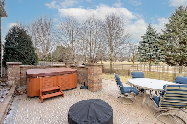 view of patio with area for grilling and a hot tub