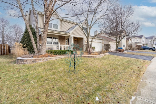 view of front of home featuring covered porch, a front yard, and a garage