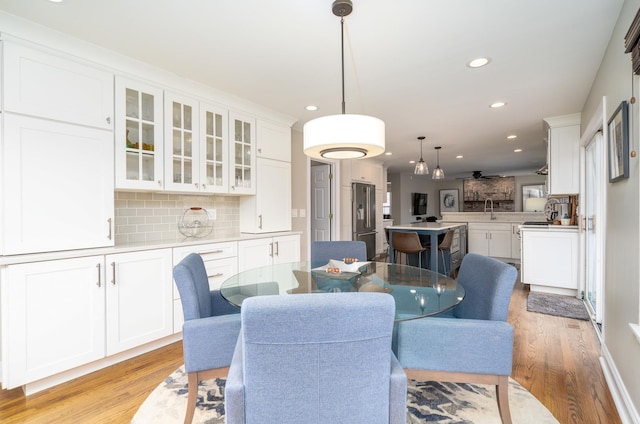 dining space with light hardwood / wood-style flooring and sink