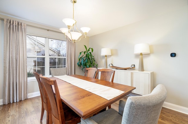 dining area featuring dark hardwood / wood-style flooring, a healthy amount of sunlight, and an inviting chandelier