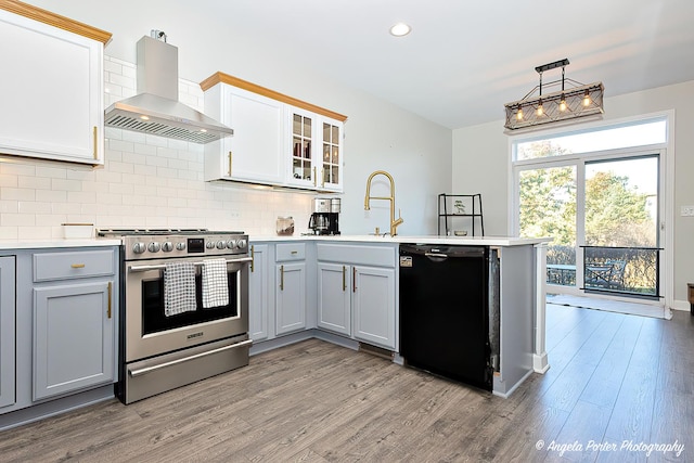 kitchen featuring dishwasher, white cabinets, wall chimney exhaust hood, and stainless steel range oven