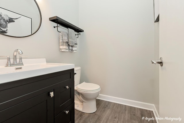 bathroom featuring wood-type flooring, vanity, and toilet