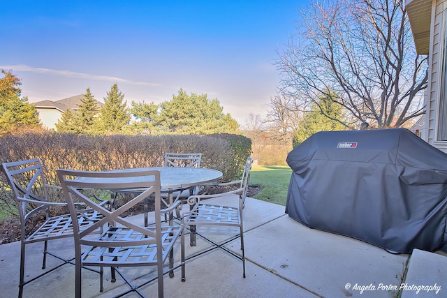 patio terrace at dusk featuring area for grilling