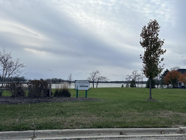 view of home's community with a water view and a yard