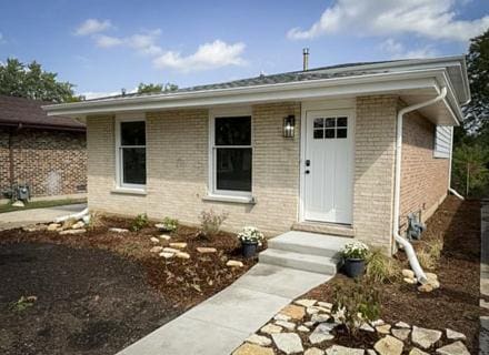 doorway to property featuring brick siding