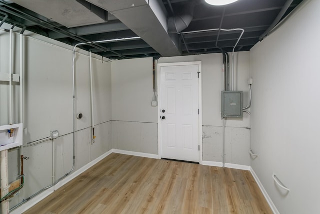 basement featuring light hardwood / wood-style floors and electric panel