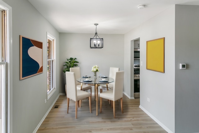 dining room featuring a notable chandelier and light wood-type flooring