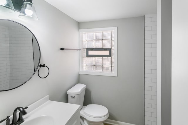 bathroom with vanity, a healthy amount of sunlight, and toilet