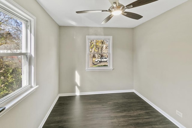 empty room featuring plenty of natural light, ceiling fan, and dark hardwood / wood-style floors