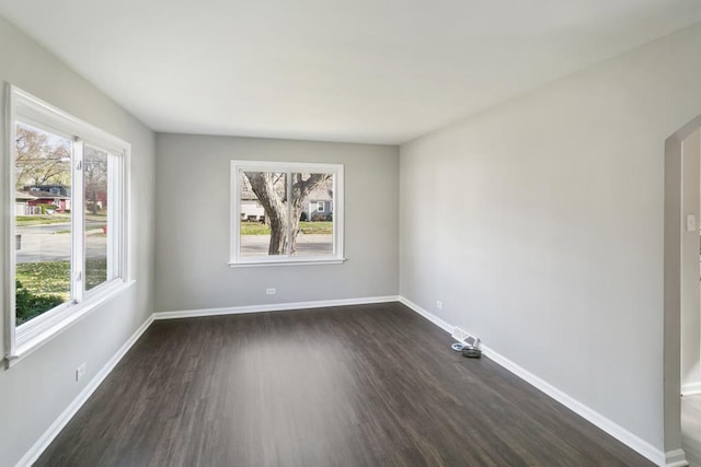 unfurnished room with dark hardwood / wood-style flooring