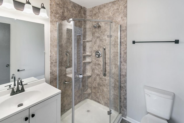 bathroom featuring vanity, toilet, and a shower with door