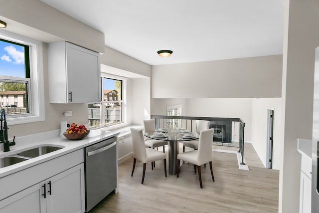 kitchen with dishwasher, white cabinets, light hardwood / wood-style floors, and sink