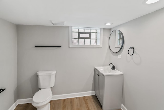 bathroom featuring vanity, wood-type flooring, and toilet