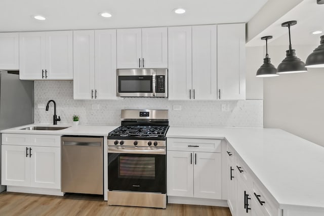 kitchen with backsplash, white cabinetry, sink, and stainless steel appliances