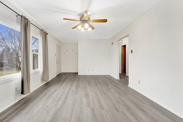 spare room featuring ceiling fan, plenty of natural light, and light hardwood / wood-style flooring