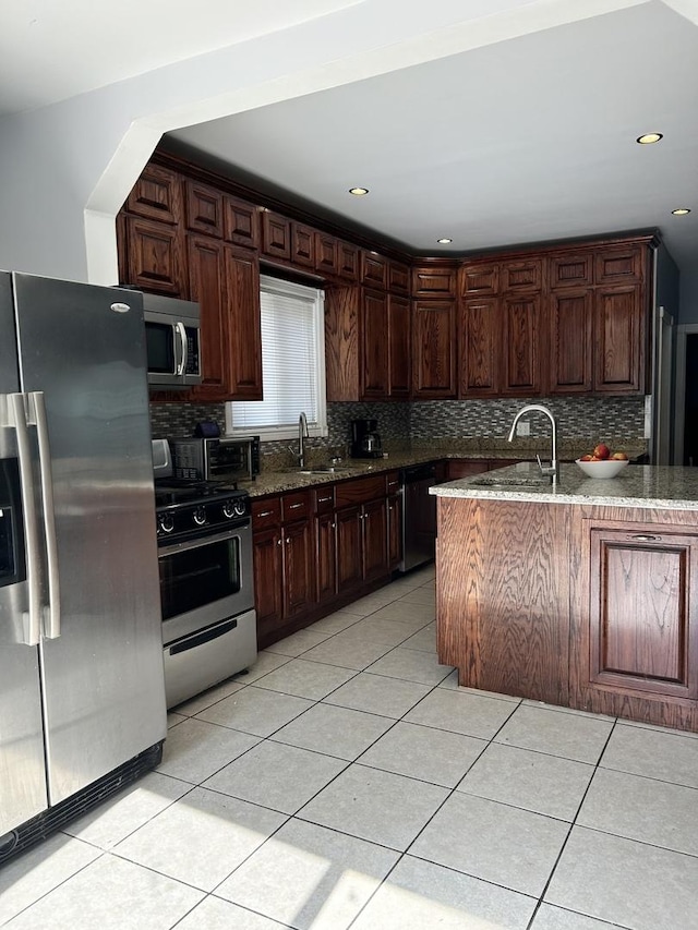 kitchen with dark brown cabinets, light tile patterned flooring, sink, and appliances with stainless steel finishes